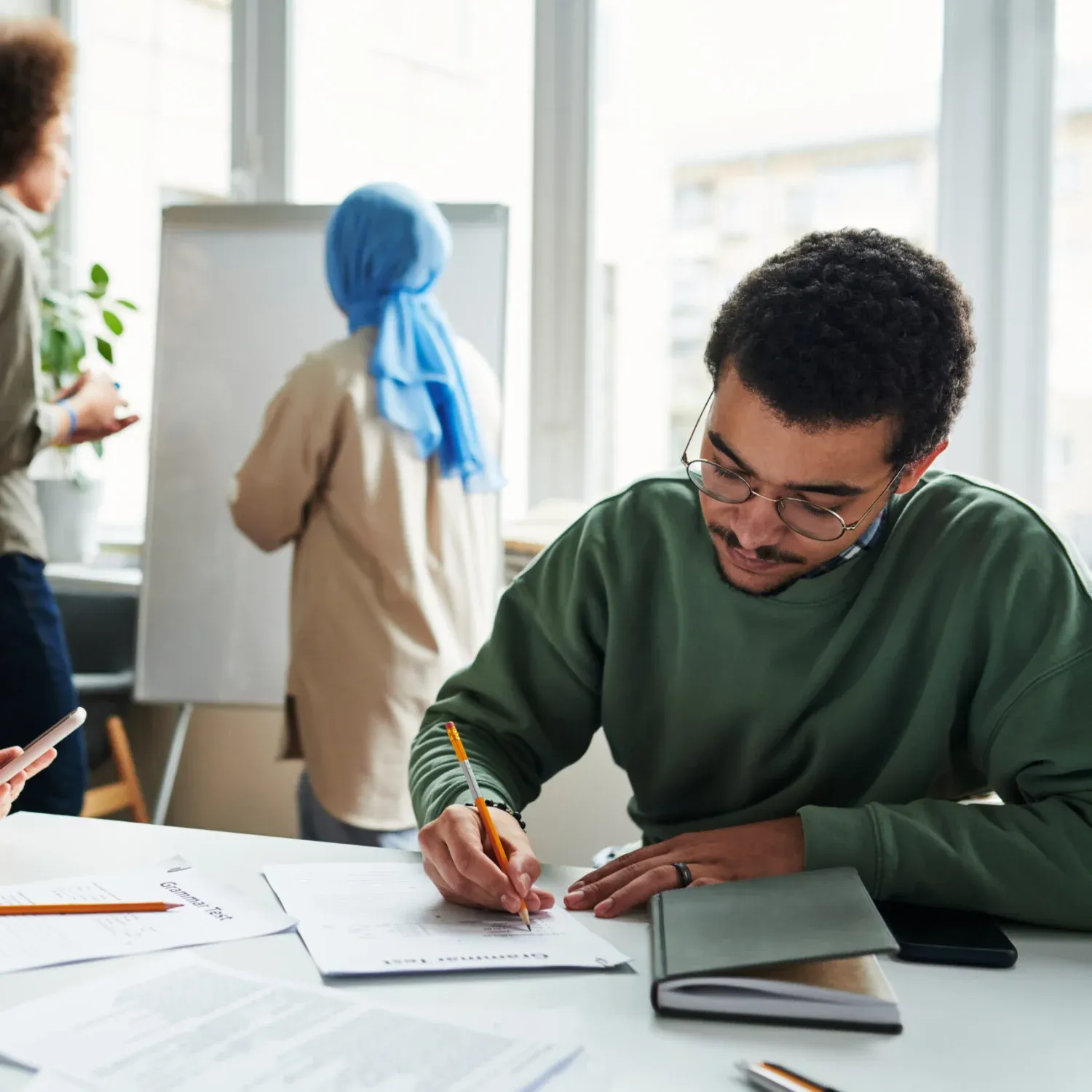 Abitur Englisch Nachhilfe in Trier: Schüler arbeiten konzentriert an Aufgaben, während die Lehrkraft Inhalte am Whiteboard erklärt.